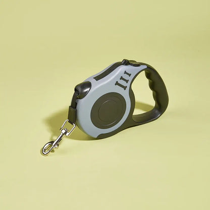 Gray and black retractable dog leash with metal clip on light yellow background