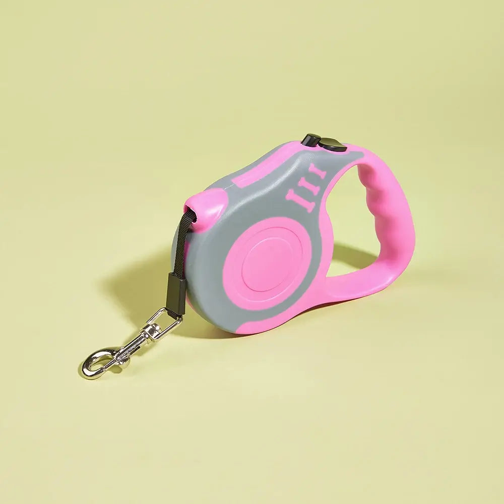 Pink and gray retractable dog leash with anti-slip handle on pastel yellow background