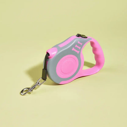 Pink and gray retractable dog leash with anti-slip handle on pastel yellow background